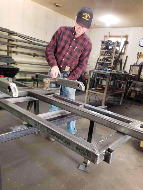 >Allan in his workshop creating a walking beam for his ATV trailers. Photo: Marilyn Collie